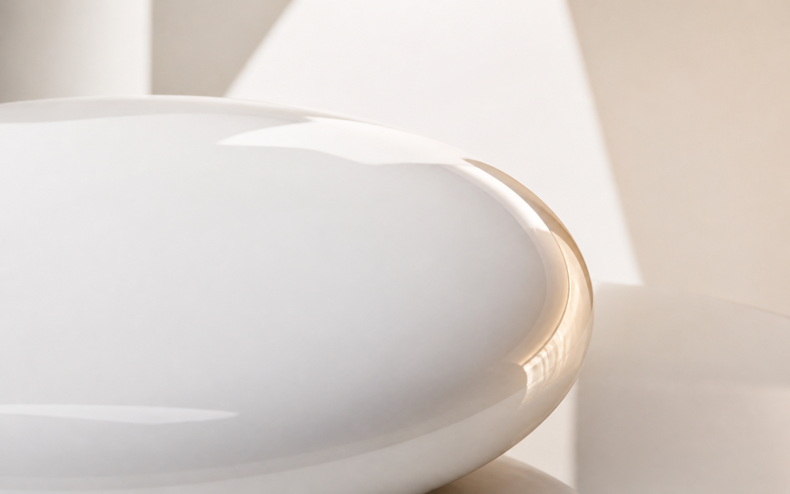 Close study of a white enamel surface curving through warm daylight