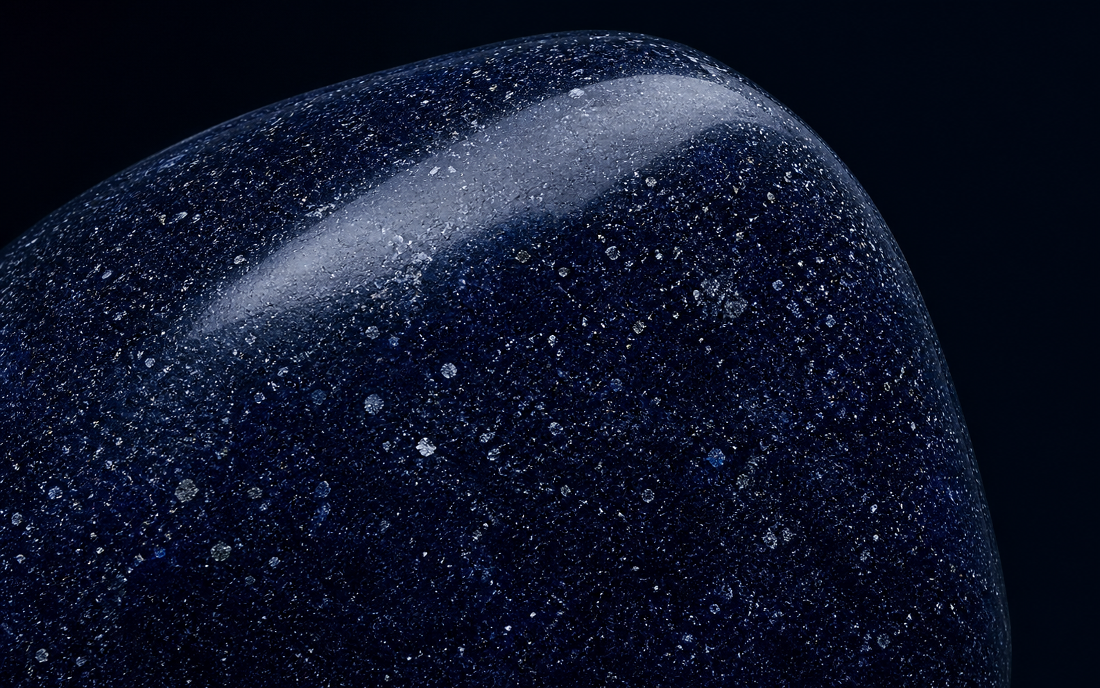 Close macro study of polished blue aventurine showing reflective inclusions at varying depths
